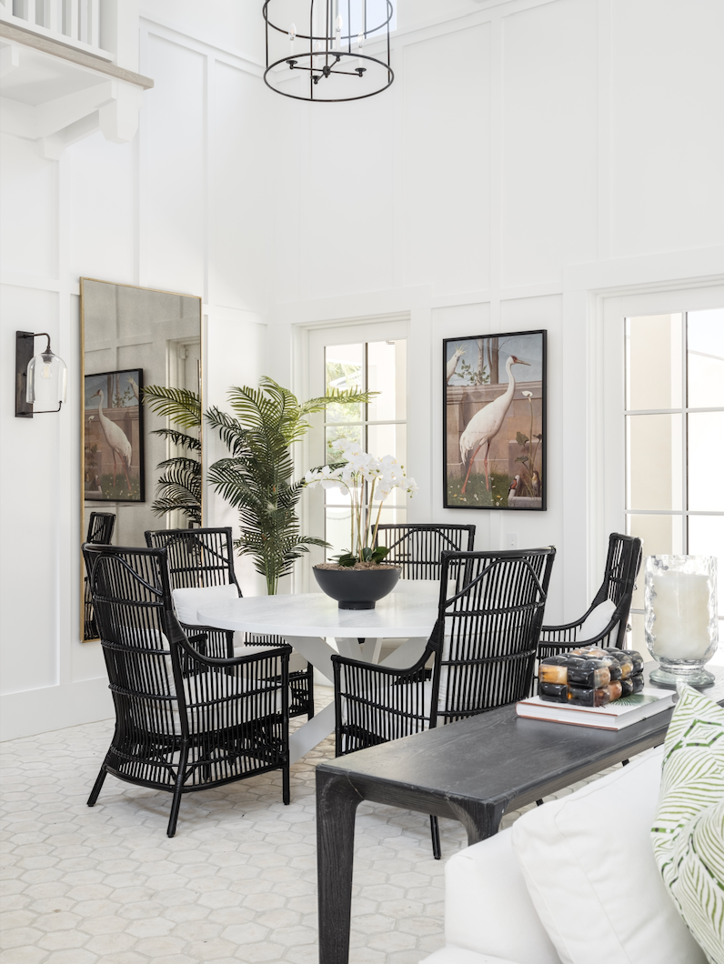 Modern dining room with black wicker chairs and a white table.